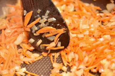 Kızartma tavasında kızartılmış sebze ve yapışmaz kaplama. Soğanlı kızarmış havuç, yakın plan.