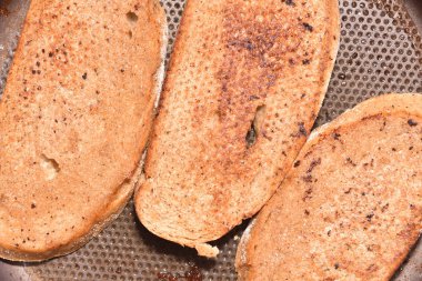 Kızartma tavasında Fransız tostu pişiriyorum. Kızartma tavasında kızgın yağda kızartılmış ekmeği kapat. Yakın plan.