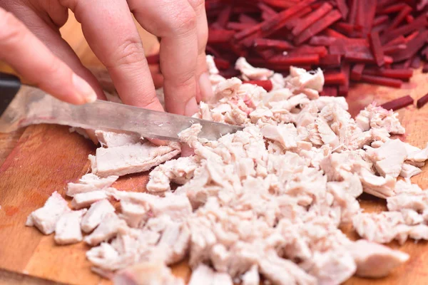 Fatias de carne de peru cozida. As mãos femininas com uma faca cortam a carne de peru fervida — Fotografia de Stock