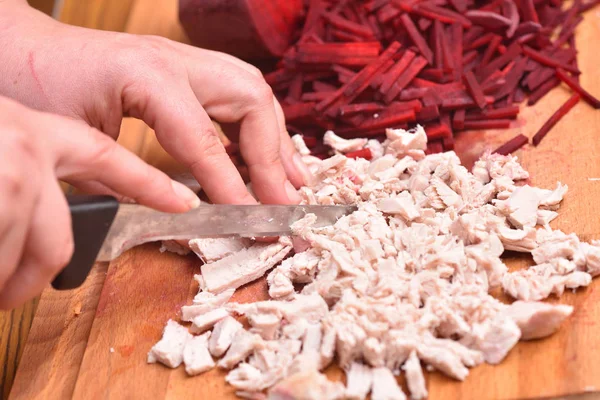 切碎煮熟的火鸡肉. 用刀割过煮过的火鸡肉的雌性手 — 图库照片