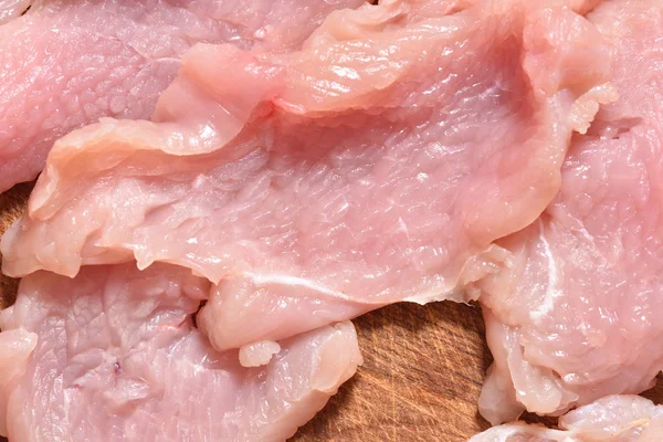 Raw and sliced turkey meat. Fresh pink turkey meat, close-up