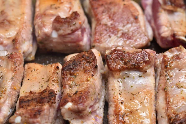 Schöne, rötliche Schweinerippchen werden in einer Pfanne gebraten. Nahaufnahme — Stockfoto