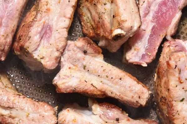 Hermosas y ruddy costillas de cerdo se fríen en una sartén. Primer plano —  Fotos de Stock