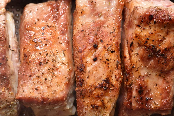 Schöne, rötliche Schweinerippchen werden in einer Pfanne gebraten. Nahaufnahme — Stockfoto