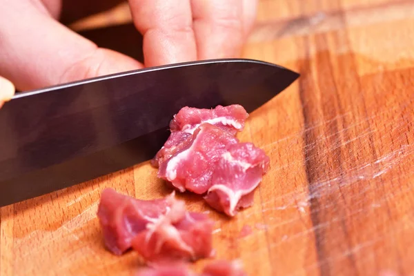 Нарезанное сырое баранину мясо. Подготовка баранины к приготовлению ужина. Нож режет мясо индейки. Крупный план — стоковое фото