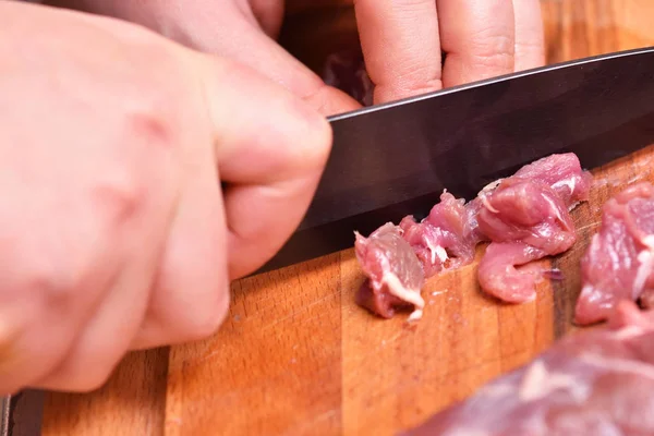 Sliced raw mutton meat. Preparation of mutton meat for cooking dinner. The knife cuts the turkey meat. Close-up