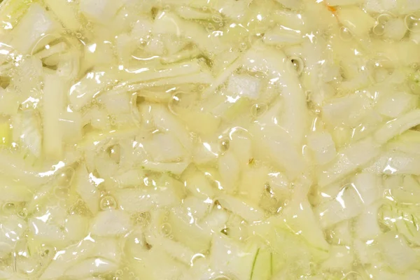 The texture of onions which is fried in a pan in sunflower oil. Close-up — Stock Photo, Image