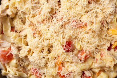 Evde makarna pişirmek. Tavada makarna ve parmesan peyniri içeriği. Yakın plan.