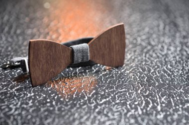 Demirden kaba bir yüzey üzerinde gri kumaşlı şık erkek kahverengi papyonu. Vahşi adamlar için suç ortağı.