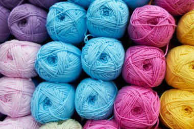 Mağazadaki rafta farklı renkler örmek için iplikler. Kapat.