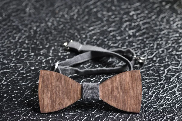 Elegante pajarita masculina de madera marrón con tela gris sobre una superficie rugosa de hierro. Accesorio para hombres brutales —  Fotos de Stock