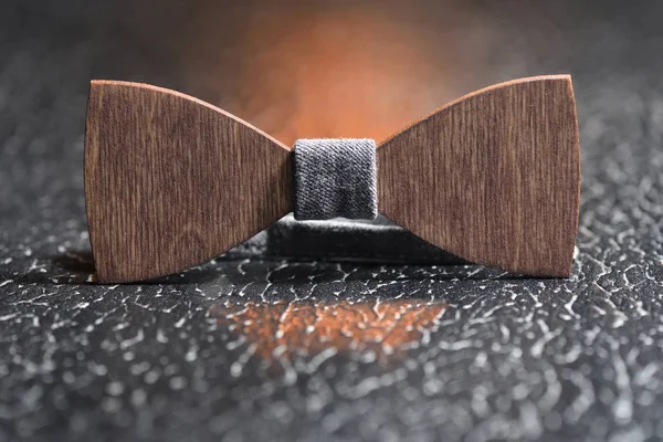 Stylish men's brown wooden bow tie with gray fabric on an iron rough surface. Accessory for brutal men — Stock Photo, Image