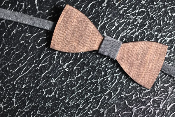 Elegante pajarita de madera marrón para hombre con tela gris sobre una superficie rugosa de hierro. Accesorio para hombres brutales — Foto de Stock