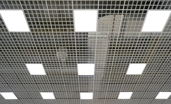 Iluminación de techo en forma de plazas en una habitación grande en un centro comercial o almacén —  Fotos de Stock