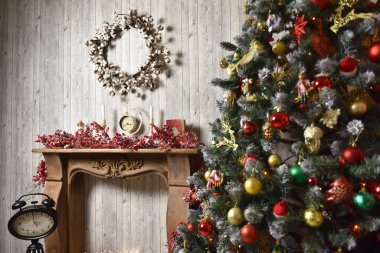 Kahverengi tonlarda bir Noel ağacı, hediyeler, ahşap bir şömine ve üç ayaklı bir saat.