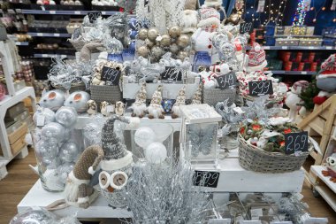 Noel ya da yılbaşı için dekoru olan bir mağazada raflar. Baykuşların, cücelerin, domuz kumbaralarının yumuşak oyuncakları Noel ağacı için fare ve top şeklinde.