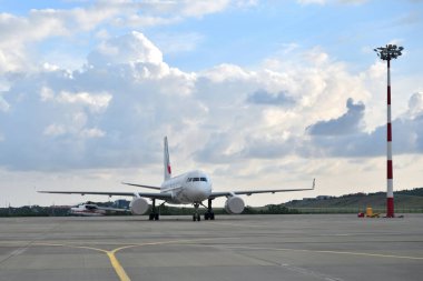 Havaalanındaki akşam manzarası boş bir kalkış pisti ve bir yolcu uçağı.