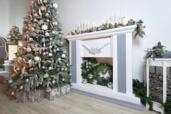 Beautiful New Year\'s interior with a white fireplace, Christmas tree