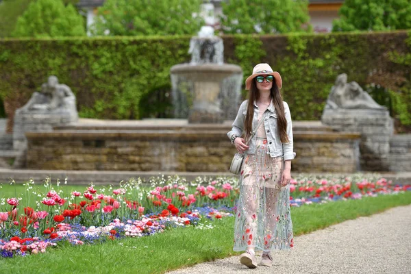 身着粉色衣服头戴粉色帽子的女游客穿过欧洲的公园 — 图库照片