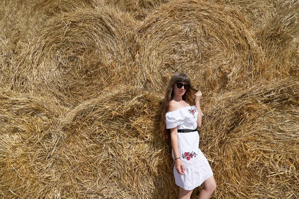 Brunetka Dívka Bílých Šatech Brýlích Pozadí Velké Kupky Sena Kulatých — Stock fotografie