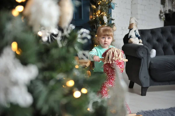 Маленька Дівчинка Сидить Червоному Коні Фоні Різдвяного Інтер Єру — стокове фото