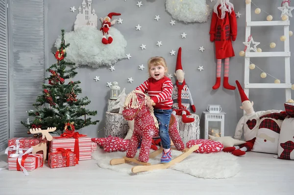 Маленька Дівчинка Сидить Червоному Коні Посміхається Фоні Різдвяного Інтер Єру — стокове фото