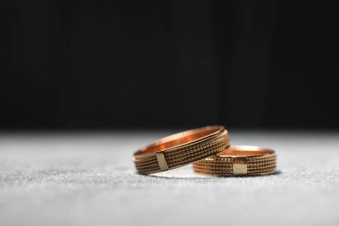 Gri yüzeyde altın alyanslar. Makro fotoğrafçılık.