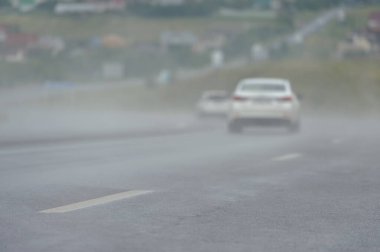 Otoyoldaki yağmurdan sonra buharlaşma. Yolda sis var. Asfaltta buharlaşma.
