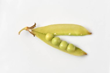 Parlak ve taze bezelyeler, beyaz arkaplanda bezelyeler olan açık kabuklar..