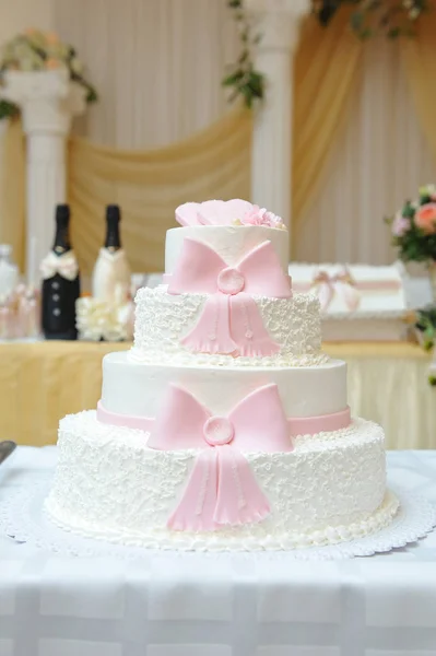 ホワイトクリームとピンクのマスチックリボンで装飾された4層のケーキ — ストック写真
