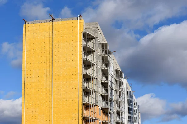 Construction of residential building and insulation of external wall with special heat-insulating material. Wall with thermal insulation against the blue sky.