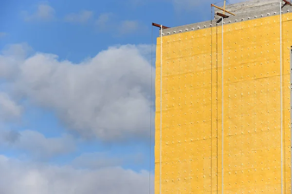 Construction of high residential building in yellow color.