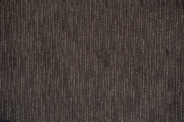 Surface of floor covering brown carpet with strips.