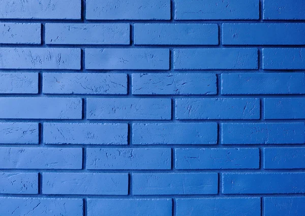 The brick wall painted in blue. Brick wall of blue color.