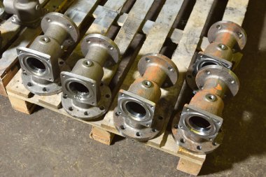 Su ve gaz için fabrika üretim vanaları. Tahta paneldeki kapakçıkların alt kısımları makinenin işleme konmasını bekliyor. Deliklerde vidalar yaratıyor..