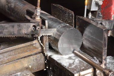 Fabrikada metali elektrikli testereyle kesme işlemi. Elektrikli testere metali kesiyor, yakın plan..