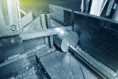 Fabrikada metali elektrikli testereyle kesme işlemi. Elektrikli testere metali kesiyor, yakın plan..
