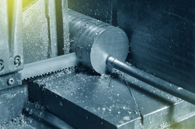 Fabrikada metali elektrikli testereyle kesme işlemi. Elektrikli testere metali kesiyor, yakın plan..