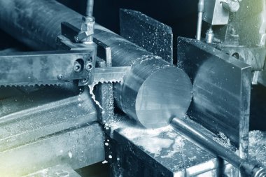 Fabrikada metali elektrikli testereyle kesme işlemi. Elektrikli testere metali kesiyor, yakın plan..