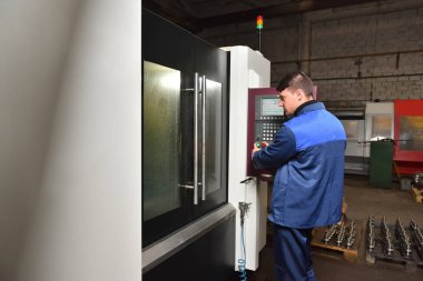 Stariy Oskol, Rusya - 18 Ocak 2018: Cnc makinesinin hangi bölümünün üretildiğini izleyen işçi.