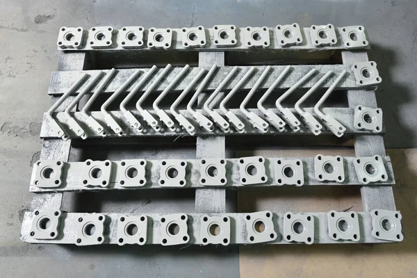 Gray-colored metal parts for creating valves on wooden board after painting for assembly.