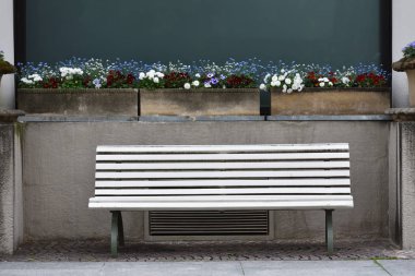 Avrupa 'da bir şehrin ön cephesinde parlak bir bank ve çiçekler. Baden Baden