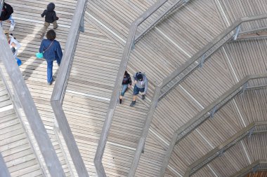 Bad Wildbad, Almanya - 22 Nisan 2019: İnsanlar Schwarzwald Ormanı 'nda kayan bir kule olan Baumwipfelpfad' da yürüyorlar. Schwarzwald ormanında yürüyen turistler için yüksek kule