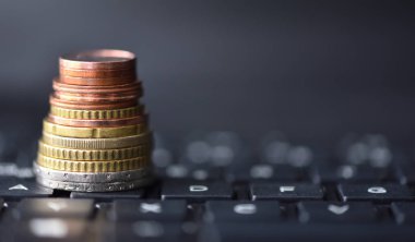 Avro sikkeleri dizüstü bilgisayarda siyah klavye üzerinde bir piramit şeklinde uzanır, metin için boşluk