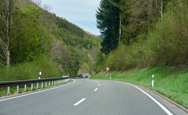 Ağaçlar arasında yol, güneşli bir gün ve Alman ormanında mavi gökyüzü olan güzel bahar manzarası Schwarzwald