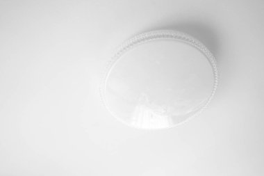 Beyaz tavan arkaplanındaki sıradan yuvarlak beyaz avize.,