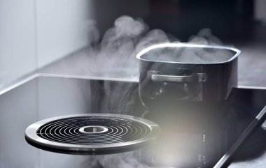 Elektrikli indüksiyon fırını. Havalandırma ve çıkarıcı kaputu var. Bu da tavadaki kaynar sudan buhar çıkarıyor.
