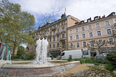Baden-Baden, Almanya - 24 Nisan 2019: Baden Baden, Augustaplatz 'da güzel bir çeşme ve çiçek ağacı