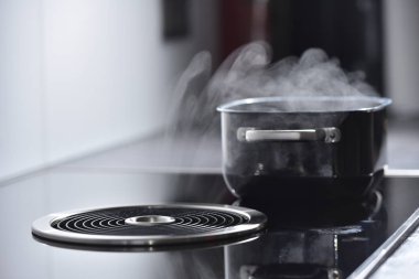Elektrikli indüksiyon fırını. Havalandırma ve çıkarıcı kaputu var. Bu da tavadaki kaynar sudan buhar çıkarıyor.