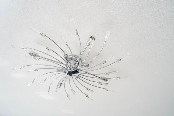 Beautiful chromed ceiling chandelier in the form of many swirling rays